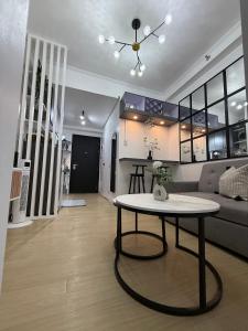 ein Wohnzimmer mit einem Tisch und einem Sofa in der Unterkunft JA2 STAYCATION @TREES RESIDENCES in Manila
