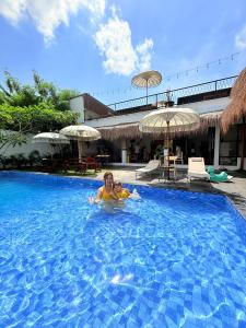 a woman in a swimming pool at a resort at D'svarga Glamping in Seturan