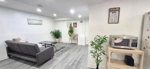 a living room with a couch and a tv at Bright & Cozy Rooms with Privated Bathrooms in Toronto in Toronto