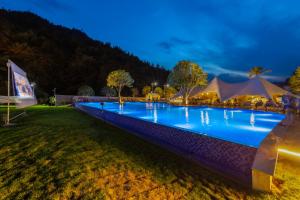 a large swimming pool at night with tents at Glamping Resort-At National Forest Park with Free Shuttle in Zhangjiajie