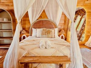 ウルワツにあるCasa Bamboo uluwatu 2のベッドとタオル2枚のある寝室