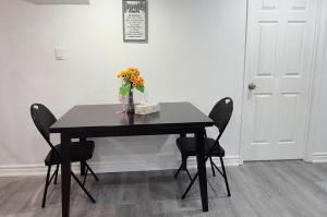 a black table with chairs and a vase of flowers at Bright & Cozy Rooms with Privated Bathrooms in Toronto in Toronto +8 photos