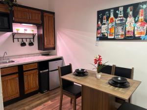 a kitchen with a table with chairs and a kitchen with bottles on the wall at Estudio práctico y confortable en segundo piso in Senecú