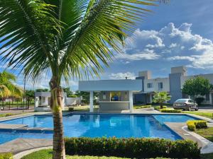 a palm tree in front of a house with a swimming pool at Casa de descanso in Veracruz