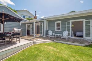 a patio with a table and chairs on a house at Quintessential Russell Cottage in Russell