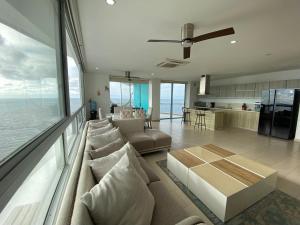 a large living room with a couch and a kitchen at Espectacular apto frente al mar in Coveñas