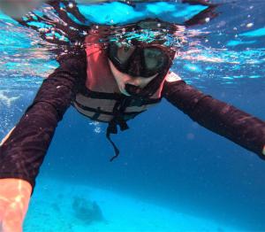 a person swimming in the water in the water at Casa Maria-River view -2 storey house in Dauis