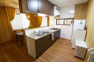 eine kleine Küche mit Spüle und Kühlschrank in der Unterkunft 北谷町宮城戸建て in Hamakawa