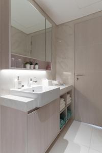 a white bathroom with a sink and a shower at Spacious 3BR Sea-View Condo Resort Amenities 2708 in Laguna Phuket