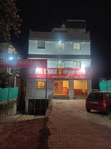 a building with a car parked in front of it at night at Hotel O Gokul Lodging in Pune