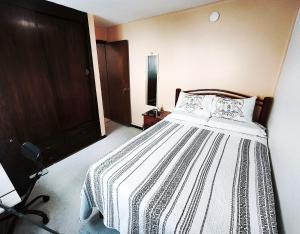 a bedroom with a bed and a wooden door at Cozy bedroom at 5 min Mexico City Airport T1 & T2 in Mexico City +1 photo