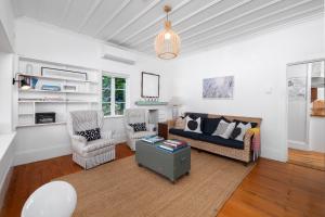 a living room with a couch and two chairs at Quintessential Russell Cottage in Russell