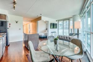 a living room with a glass table and chairs at 2BR Condo - Free Parking - Park & City View in Toronto