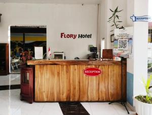 Un cartel que dice "Flowy Hotel" en el mostrador de una tienda. en RedDoorz at Flory Hotel Jalan Parangtritis, en Timuran 29 fotos más