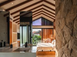 a bedroom with a bed and a large window at Blacksand Villas Bingin, Uluwatu by Sandara in Uluwatu