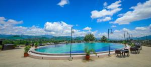 a large pool with tables and chairs on a resort at Luang Prabang View Hotel in Luang Prabang