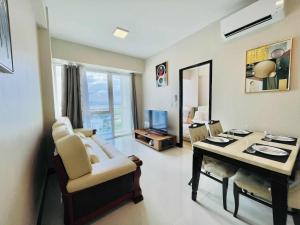 a living room with a couch and a table and a dining room at Heart of Mactan Newtown big space with free wifi and pool access in Punta Engaño