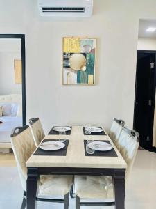 a dining room table with chairs and a painting on the wall at Heart of Mactan Newtown big space with free wifi and pool access in Punta Engaño +22 photos
