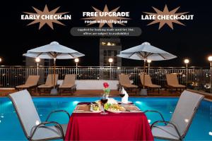 a table with food on it next to a pool at Galliot Hotel Nha Trang in Nha Trang