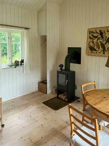 a living room with a wood stove and a table at Sustainable Cabin In Beech Forest At Mellby Käsk in Södra Mellby