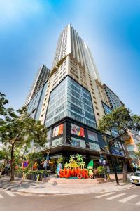 a tall building with a sign in front of it at Gold Coast Apartment Nha Trang in Nha Trang