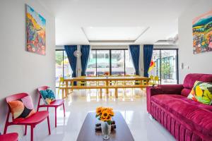een woonkamer met een rode bank en een tafel bij Love U Pool Villa Hua Hin-Pet Friendly House in Hua Hin