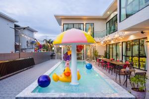 een zwembad met twee rubberen eendjes en een parasol bij Love U Pool Villa Hua Hin-Pet Friendly House in Hua Hin