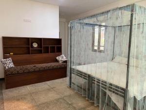 a bedroom with a bed and a glass wall at Sri Holiday House - Hikkaduwa in Hikkaduwa