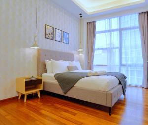 Un dormitorio con una cama y una ventana grande en The Azure Residences, en Kampong Baharu Sungai Way