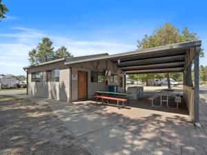 a shed with a bench on a patio at Borderland Wodonga Holiday Park in Wodonga