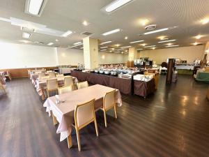a dining room with tables and chairs and a whiteboard at Hokkaido Greenland Hotel Sunplaza in Iwamizawa