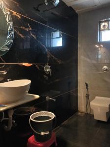 Baño negro con lavabo y aseo en Daksh 3bhk villa wifi call, en Mahabaleshwar