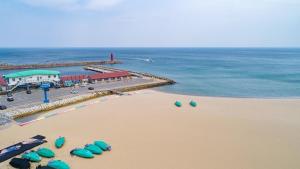 an overhead view of a beach with umbrellas and the ocean at Yangyang Naksaneuisangdae Pension in Chosan-ni