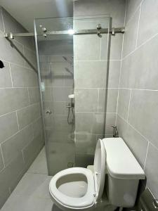 a bathroom with a toilet and a shower at The Merry Meg Residences in Mandaue City