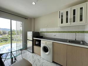 una cocina con lavadora y fregadero en Phuket Kathu Pluscondo 37 74, en Kathu