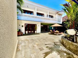 サヌールにあるBright & Spacious Luxury 3BR Villa with Private Poolのパティオ付きの中庭がある大きな白い建物