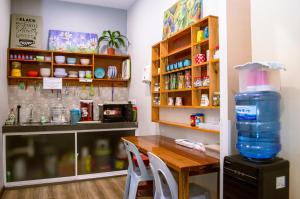 a kitchen with a table and a large bottle of water at Labuan Avenue Hotel in Victoria