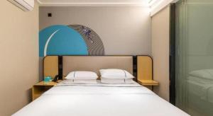 a bedroom with a bed with two pillows on it at City Comfort Inn Wuhan Hangkong Road Tongji Hospital in Wuhan