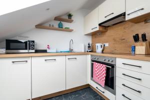a kitchen with white cabinets and a stove at 65m2 Apartment near Vienna - Up to 6 Guests - Self Check-in - Free Parking in Purkersdorf
