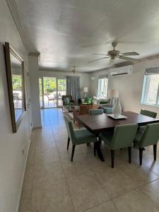 a dining room with a wooden table and green chairs at Villas on the Green Cap estate in Gros Islet