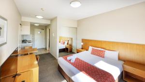a bedroom with a large bed and a small room at Gladstone Downtown Central Apartment Hotel Official in Gladstone +38 photos
