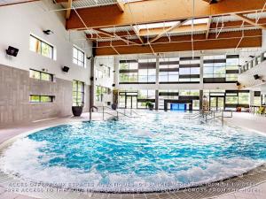 a large swimming pool in a large building at Novotel Megève Mont-Blanc in Megève