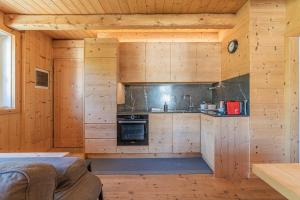 a kitchen in a log cabin with wooden walls at Alpine Heart in Falcade