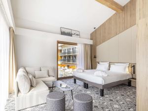 ムジェーヴにあるNovotel Megève Mont-Blancのベッドとソファのあるホテルの部屋 +103枚の写真