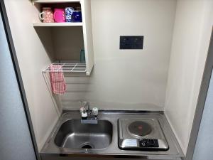 a small kitchen with a sink in a small room at hostel sunflower202 in Osaka +24 photos