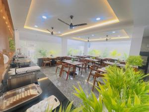 a restaurant with wooden tables and chairs and plants at Hotel Aurora Bliss in Hyderabad