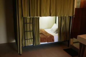 a bed in a room with a window and a ladder at Tide and Tribe hostel in Kuta Lombok