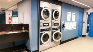 uma lavandaria com três máquinas de lavar roupa e um lavatório em ASA | Loft UP 309 | Lado da FURB | Oktoberfest em Blumenau