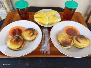 deux assiettes de nourriture sur un plateau en bois avec des assiettes de nourriture dans l'établissement Griya Bausasran, à Sentool