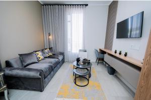 Trilogy studio apartment 831 في بريتوريا: غرفة معيشة مع أريكة وطاولة